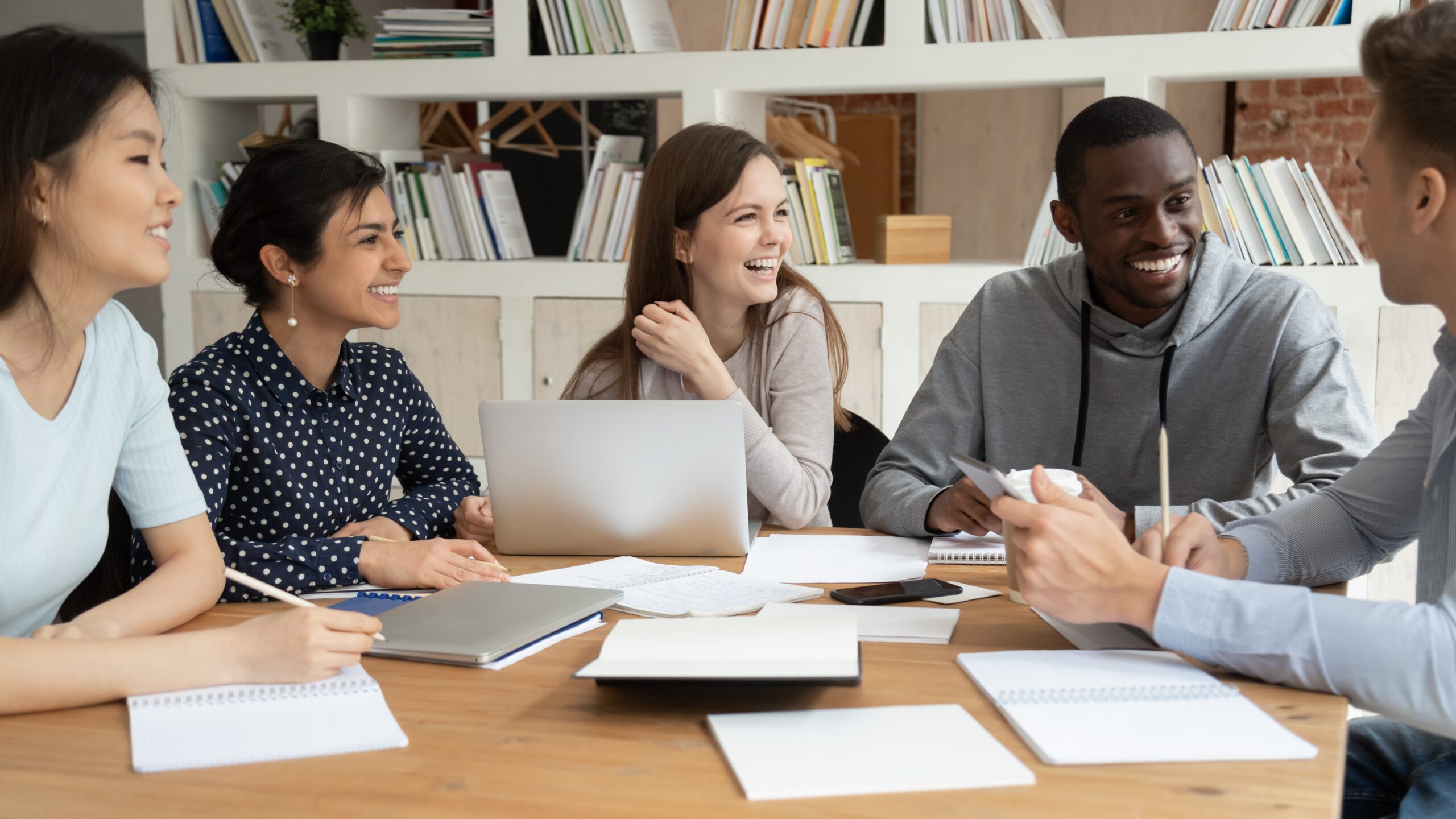 Max Academia - overjoyed Multiracial Young People Sit At Table With Laptop And
